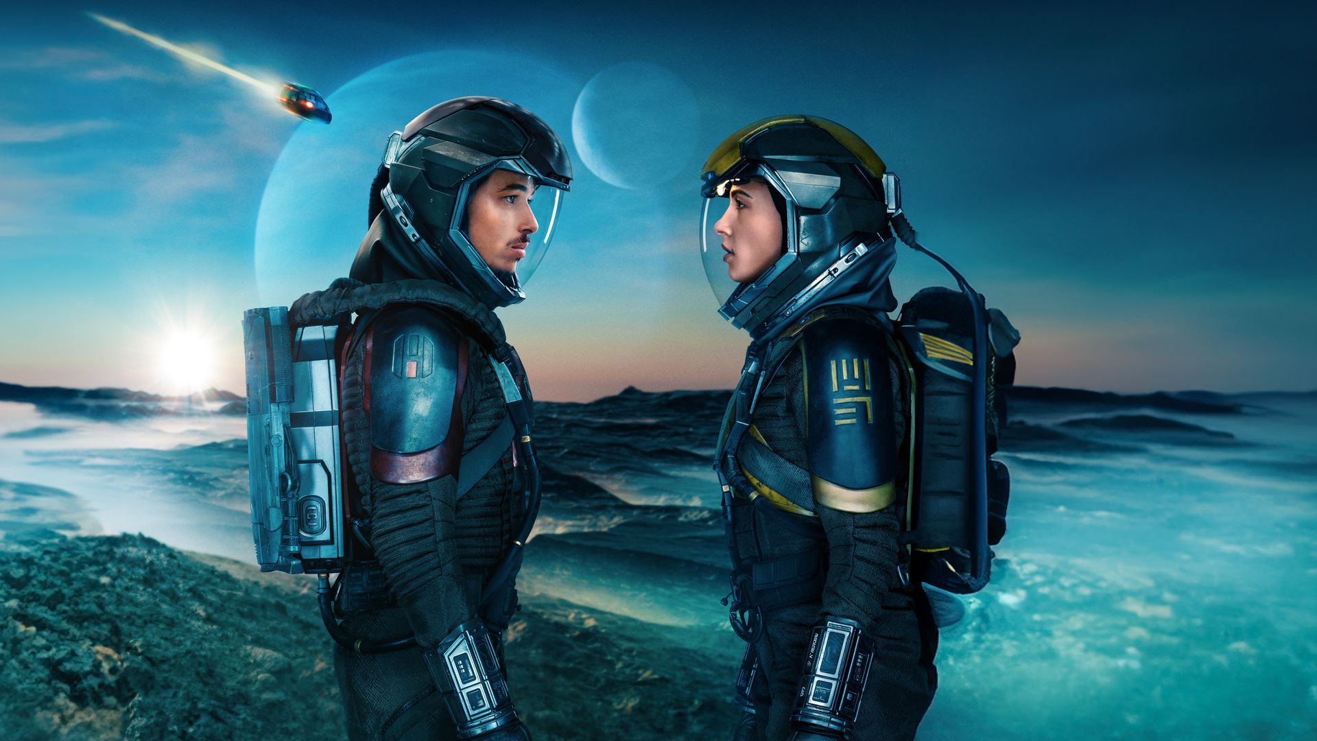 Imagen en la que se muestra a los dos protagonistas mirándose uno frente al otro con la imagen de una nave estrellándose al fondo y, aún más atrás, un planeta.