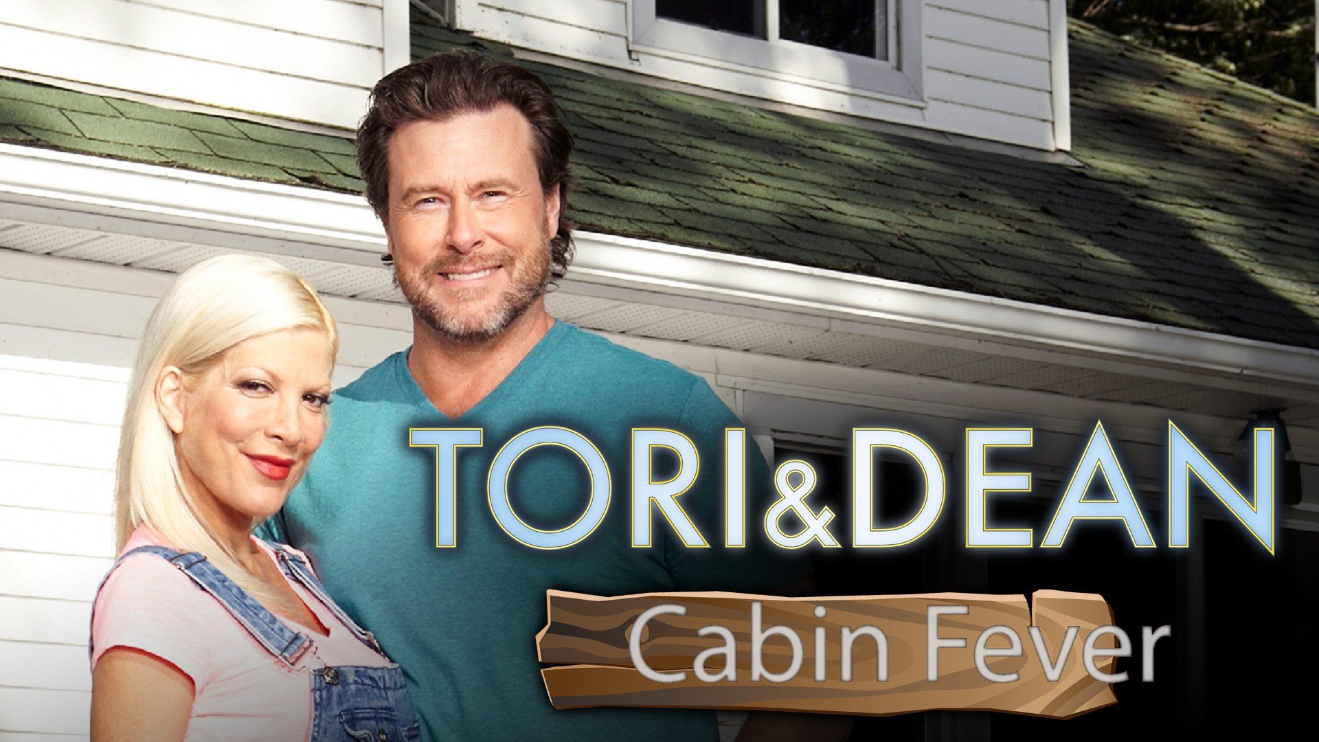 Promotional image of Tori Spelling and Dean McDermott for their reality show Tori & Dean: Cabin Fever, standing in front of a white house with green roofing.